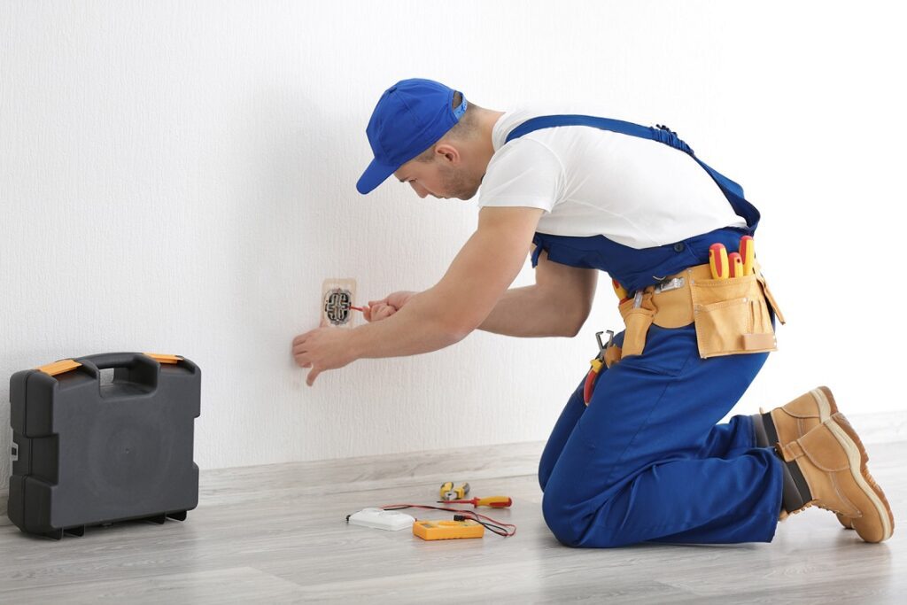 A view of an electrician repairing an outlet