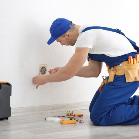 A view of an electrician repairing an outlet